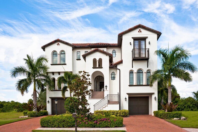 A grand Spanish-style villa with lush landscaping, showcasing expert villa construction in Bangalore